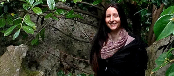 Photo of Chloe Folan in her garden smiling.